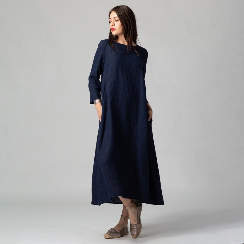 Minimalist maxi linen dress in Night Blue. Fitted in the upper part it flared generously down to the ankles. It features ¾ set in sleeves and side pockets. The wide optional belt offers various styling options.