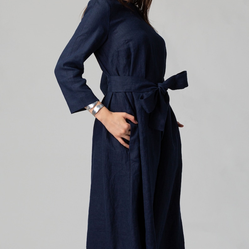 Minimalist maxi linen dress in Night Blue. Fitted in the upper part it flared generously down to the ankles. It features ¾ set in sleeves and side pockets. The wide optional belt offers various styling options.