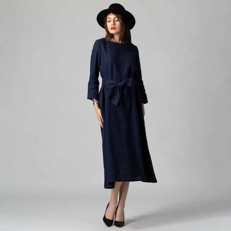 Minimalist maxi linen dress in Night Blue. Fitted in the upper part it flared generously down to the ankles. It features ¾ set in sleeves and side pockets. The wide optional belt offers various styling options.