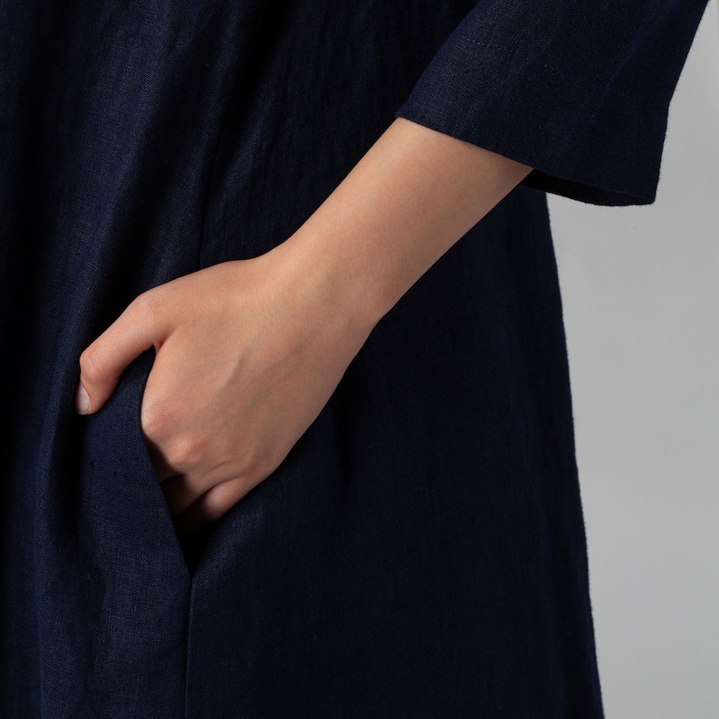Minimalist maxi linen dress in Night Blue. Fitted in the upper part it flared generously down to the ankles. It features ¾ set in sleeves and side pockets. The wide optional belt offers various styling options.