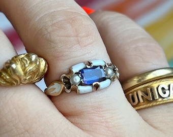 Antique late victorian ring, decorated with white enamel and set with a blue synthetic sapphire