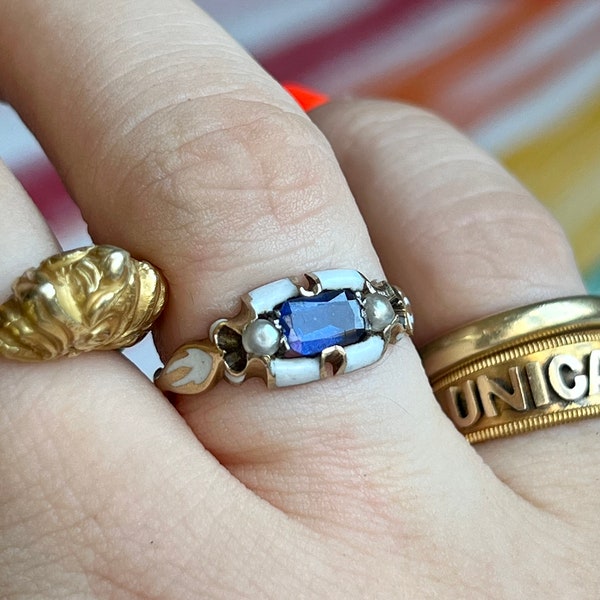 Antique late victorian ring, decorated with white enamel and set with a blue synthetic sapphire