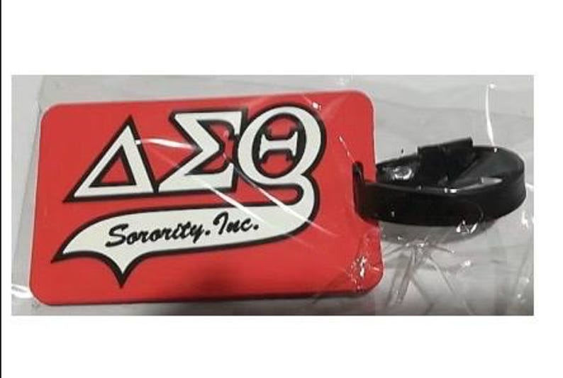 May include: Red luggage tag with white lettering that reads "&Delta;&Sigma;&Theta; Sorority, Inc.". The tag has a black plastic loop.