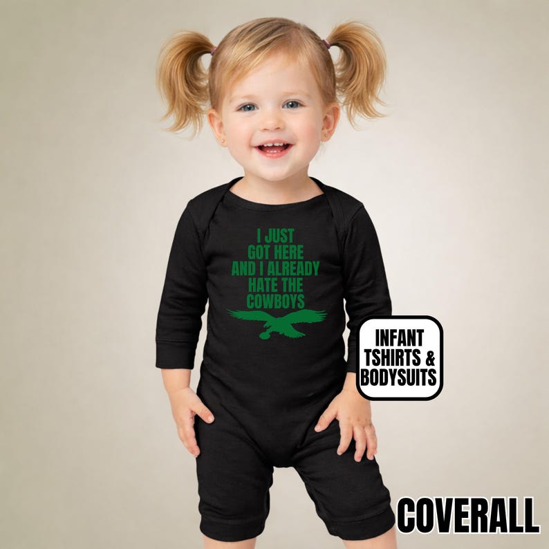 Puede incluir: Un body negro de manga larga para beb&eacute; con el texto verde I JUST GOT HERE AND I ALREADY HATE THE COWBOYS sobre un gr&aacute;fico de &aacute;guila verde. La prenda incluye una peque&ntilde;a etiqueta blanca con el texto INFANT TSHIRTS & BODYSUITS.