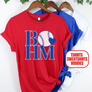 May include: Red t-shirt with a blue baseball and the text "BOHM" in blue. The t-shirt is available in other colors. T-shirts, sweatshirts, and hoodies are available.