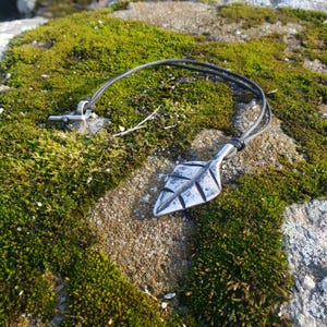 Collar con forma de hoja forjada a mano sobre cordón encerado con herrajes de acero inoxidable.