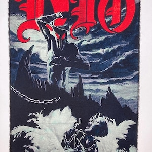 Puede incluir: Un parche rectangular negro con la palabra "DIO" en rojo en una fuente gótica. La imagen representa una figura encadenada con un casco con cuernos, una figura en el agua y un cielo tormentoso. El parche mide aproximadamente 10 cm por 15 cm.