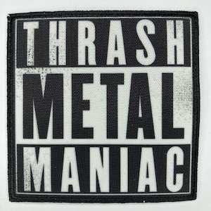 May include: Black and white embroidered patch with the text "THRASH METAL MANIAC" in a bold, blocky font.