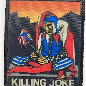 Puede incluir: Un parche de tela rectangular que muestra a un bufón con un traje azul y rojo sentado sobre un fondo naranja y azul oscuro. El bufón sostiene un pequeño bastón con cabeza de bufón. El texto KILLING JOKE está impreso en blanco abajo.