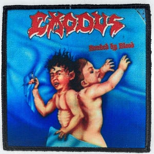 Peut inclure: Un patch tissé noir et blanc avec une bande rouge autour du bord. Le patch présente une bande avec le mot "EXODUS" en lettres rouges et les mots "Bonded by Blood" en lettres rouges plus petites. L'image montre deux bébés avec un tissu bleu et blanc autour d'eux.