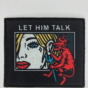 Puede incluir: Parche bordado negro con el texto "LET HIM TALK" en blanco. El parche presenta una imagen de dibujos animados de una mujer con un diablo sentado en su oreja, sosteniendo un tenedor.