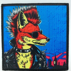 Könnte beinhalten: Quadratischer Aufnäher mit einem Punkrock-Fuchs mit rotem Irokesenschnitt, Sonnenbrille und schwarzer Lederjacke. Der Fuchs ist vor einem blauen Hintergrund mit Stadtlandschaft platziert. Der Aufnäher hat einen schwarzen Rand.