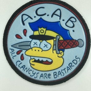 Puede incluir: Un parche bordado circular con fondo azul claro y borde negro. Presenta un personaje de dibujos animados amarillo con gorra de policía azul, un cuchillo atravesando la cabeza, ojos en forma de X y el texto A.C.A.B. ALL CLANCYS ARE BASTARDS.