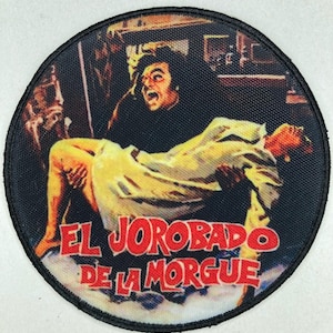 Puede incluir: Parche redondo con una escena de la película "El Jorobado de la Morgue". La imagen muestra a un hombre cargando a otra persona, con el título en letras rojas. El parche tiene un borde negro.