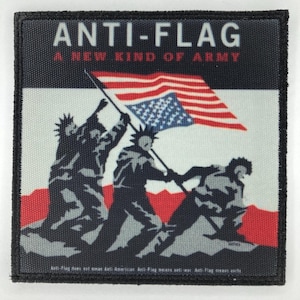 Puede incluir: Un parche de tela cuadrado con borde negro que muestra tres figuras levantando una bandera estadounidense. El texto ANTI-FLAG y A NEW KIND OF ARMY aparece en la parte superior en blanco y rojo. Hay texto pequeño en el borde inferior.