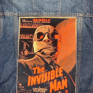 Puede incluir: Un cartel de película vintage para "El hombre invisible" con un primer plano de la cara del personaje principal, parcialmente oscurecida por vendas, con gafas protectoras. El cartel está en un esquema de color rojo oscuro, naranja y amarillo con el título en letras blancas en negrita.