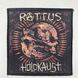May include: Black and orange embroidered patch with a skull and crossbones design. The text "ROT'US HOLOKAUST" is printed on the patch.