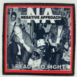 Könnte beinhalten: Ein quadratischer Stoffaufnäher mit einem Schwarz-Weiß-Foto einer Band auf der Bühne. Der Text "NA NEGATIVE APPROACH" steht oben und "READY TO FIGHT" ist unten aufgedruckt. Der Aufnäher hat einen dicken roten und schwarzen Rand.