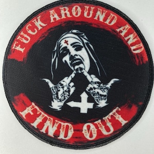 Puede incluir: Parche redondo negro con texto y gráficos rojos y blancos. El texto dice "FUCK AROUND AND FIND OUT". El gráfico es una monja con los dedos en el aire, con una cruz en el centro.