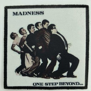 May include: A rectangular embroidered patch featuring a graphic of five figures in suits leaning forward in a line. The text MADNESS is printed in the top left corner, and the text ONE STEP BEYOND... is printed along the bottom edge.