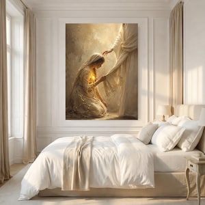 May include: A large rectangular wall art print featuring a kneeling figure in a light-colored robe reaching toward the hem of a standing figure draped in flowing white fabric. The scene is rendered in warm, golden, and cream tones with soft lighting.