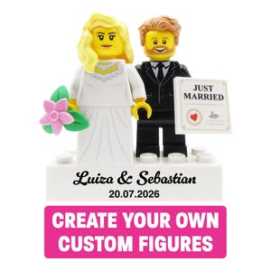 Op de afbeelding: Twee bruiloft-minifiguren op een witte basis met de namen Luiza & Sebastian en de datum 20.07.2026. De bruid draagt een witte jurk en houdt een roze bloem vast, terwijl de bruidegom een zwart pak draagt en een bordje met JUST MARRIED vasthoudt.