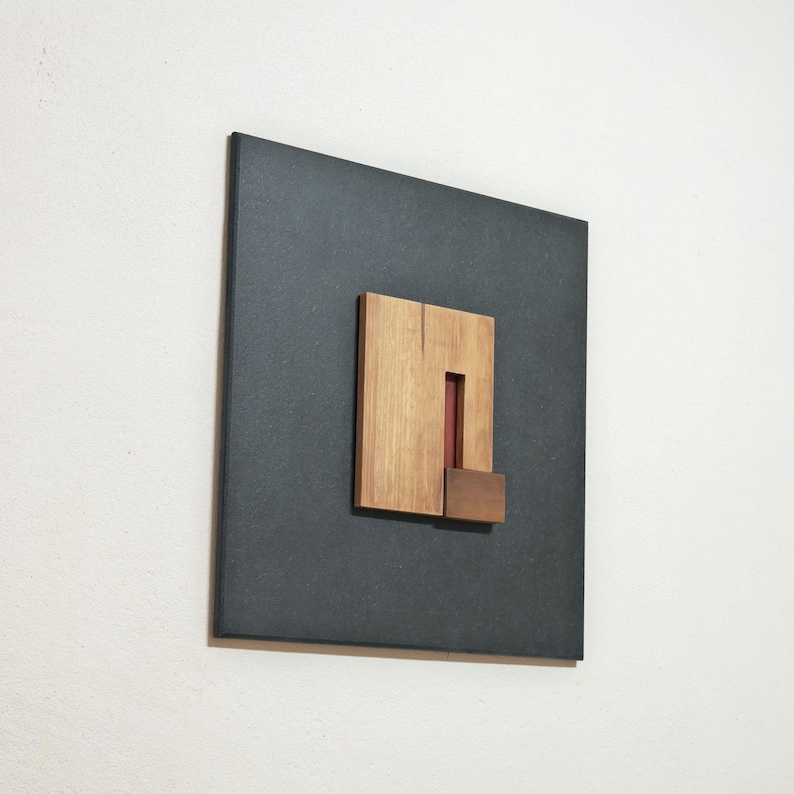 black and multiple wood tones artwork hanging on a white wall