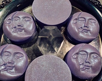 May include: Six purple moon-shaped soap bars with a glittery finish. The soaps are arranged on a silver tray with a crystal in the center.