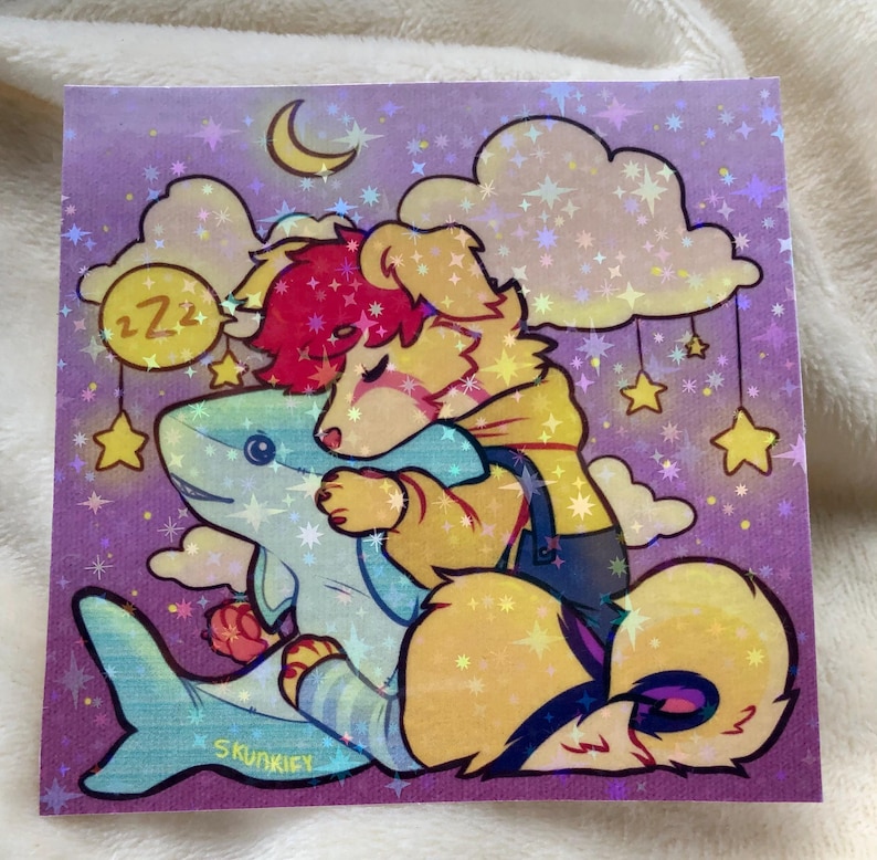 May include: A square holographic sticker featuring a cartoon illustration of a yellow dog with pink hair hugging a blue shark plush. The background is a purple night sky with clouds, a crescent moon, hanging stars, and a yellow circle with ZZZ text.