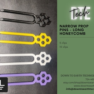 May include: Four narrow prop pins with a honeycomb design. The pins are black, yellow, white, and purple. The pins are long and have a slight bend at the top. The text "Tech" is in the upper right corner of the image. The text "NARROW PROP PINS - LONG HONEYCOMB" is below the text "Tech". The text "5 clips $2.50" and "10 clips $4.00" is below the text "NARROW PROP PINS - LONG HONEYCOMB". The text "DOWN TO EARTH TECHNOLOGIES 724-469-0886 etsy.com/shop/downtoearthtech www.downtoearth.tech info@downtoearthtech.com" is in the lower right corner of the image.