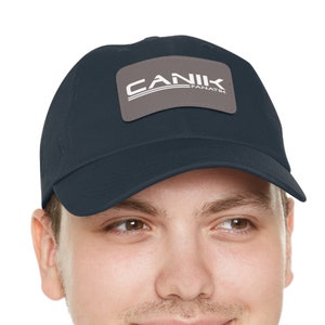 May include: A navy blue baseball cap with a gray patch featuring the white text "CANIK PANATIR".