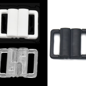 May include: Three plastic bra clasps in different colors: white, clear, and black. The clasps are designed to be used for adjusting the fit of a bra.
