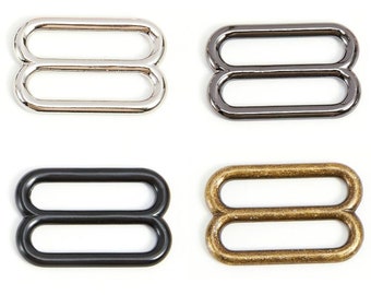 May include: Four metal slider buckles in different finishes: silver, black nickel, black, and antique brass.