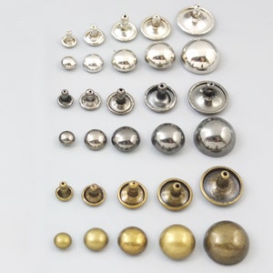 May include: Assortment of metal dome-shaped studs in silver, black, and brass finishes. The studs have a variety of sizes and are ideal for crafting and DIY projects.