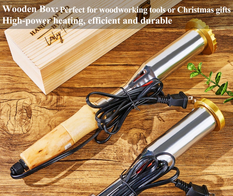 K&ouml;nnte beinhalten: Zwei Holzbrennwerkzeuge mit Holzgriffen und schwarzen Kabeln. Die Werkzeuge befinden sich auf einer Holzoberfl&auml;che. Der Text "HAND CRAFTED" und "Lody Pas" ist auf einer Holzkiste im Hintergrund sichtbar.