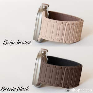 May include: Two smart watch bands in beige brown and brown black. The beige brown band is a light tan color, while the brown black band is a dark brown. The bands have a magnetic closure and a rectangular design. The watch cases are silver.
