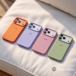 May include: Four smartphone cases in orange, lavender, pink, and sage green. Each case features a camera cutout, a personalized two-letter monogram, and a bottom charging port opening. The text shop icicco is visible in the bottom right corner.