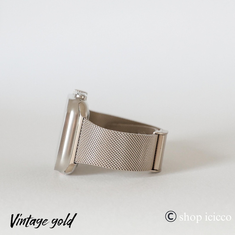 K&ouml;nnte beinhalten: Eine silberfarbene Smartwatch mit einem Mesh-Armband. Das Zifferblatt der Uhr ist rechteckig mit abgerundeter Kante. Das Armband besteht aus feinem, gewebtem Metall. Die Worte "Vintage gold" sind unten links in Schreibschrift gedruckt.