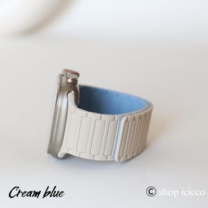 May include: A cream and light blue watch band with a silver watch face. The band is made of rectangular segments. The text "Cream blue" is at the bottom left of the image.