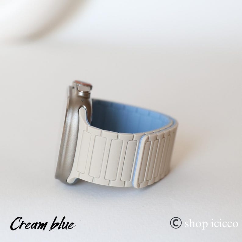 May include: A cream and light blue watch band with a silver watch face. The band is made of rectangular segments. The text "Cream blue" is at the bottom left of the image.