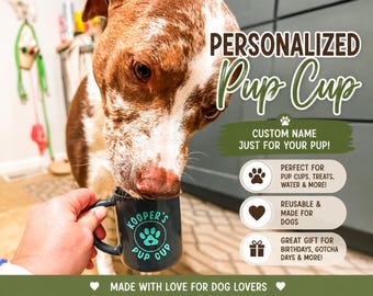 May include: A dark grey ceramic mug featuring the text Kooper's Pup Cup and a paw print graphic. The mug is held near a brown and white dog. Text on the image includes Personalized Pup Cup, Custom Name Just For Your Pup, and Made With Love.