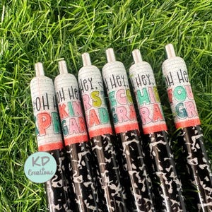 May include: Six black and white patterned pens with colorful text on each. The text reads "Oh Hey Kindergarten", "Oh Hey First Grade", "Oh Hey Second Grade", "Oh Hey Third Grade", "Oh Hey Fourth Grade", and "Oh Hey Fifth Grade".