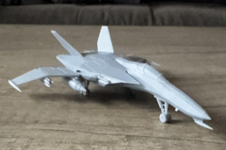 Puede incluir: Un modelo de avi&oacute;n gris con un dise&ntilde;o elegante, con alas, cola y tren de aterrizaje. El avi&oacute;n de juguete es una r&eacute;plica en miniatura de un caza a reacci&oacute;n, que muestra detalles.
