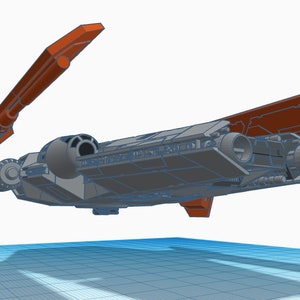 Peut inclure: Un mod&egrave;le de vaisseau spatial gris avec des ailes orange. Les ailes sont ouvertes et le vaisseau spatial est en l&eacute;vitation dans les airs.