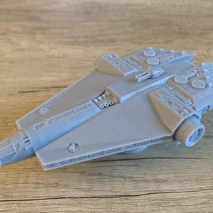 May include: A gray 3D printed model of a spaceship with detailed surface textures and a large engine on the back.