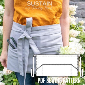 May include: A light gray waist apron featuring a front pocket and a tie closure at the waist. The apron is worn over a mustard yellow top and blue jeans. A black and white line drawing of the apron pattern is overlaid with the text PDF SEWING PATTERN.
