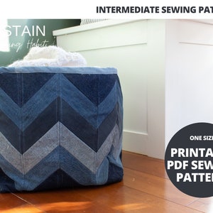 May include: A blue denim storage basket with a chevron pattern. The basket is filled with white fabric and is sitting on a wooden floor. The text "ONE SIZE PRINTABLE PDF SEWING PATTERN" is on a black circle.