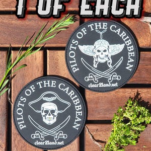 Puede incluir: Dos parches redondos negros con texto y gráficos blancos. Los parches están sobre una superficie de madera. El texto en los parches dice "Pilots of the Caribbean". Un parche presenta una calavera con un sombrero de pirata y el otro presenta una calavera con un casco de piloto y alas.