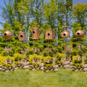 May include: Six copper wind chimes shaped like teapots with birdhouse openings, hanging from chains with small bells. The wind chimes are hanging in a garden setting.