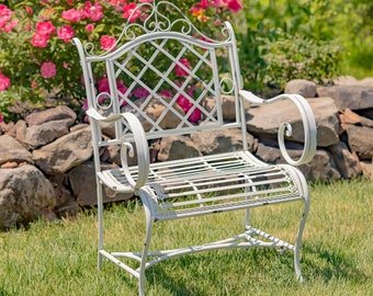 May include: A white metal garden chair featuring a lattice backrest with decorative scrollwork at the top, curved armrests, and a slatted seat. The frame displays a distressed finish with visible wear along the edges and joints of the structure.